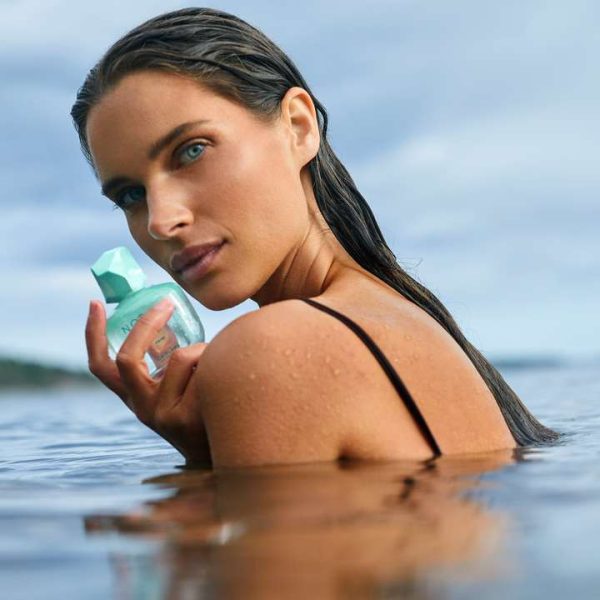 Kobieta trzymająca w ręku wodę perfumowną nordic water od oriflame